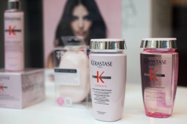 Kerastase marka bir kuaför dükkanında pembe şampuan ve losyon şişeleri.