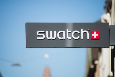 Caddedeki dükkanın önündeki levhada Swatch logosu