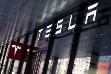 Tesla logosu şehirdeki araba perakendecisi cephesinde.