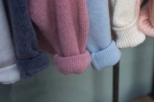 Primer plano de pullovers de lana de colores en perchas en una tienda de moda — Foto de Stock
