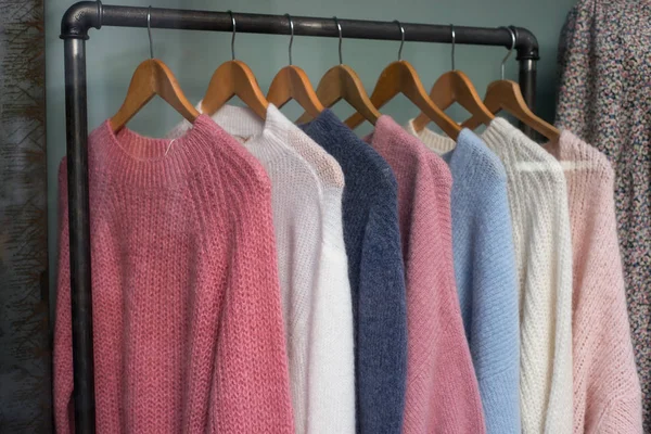 Primer plano de pullovers de lana de colores en perchas en una tienda de moda — Foto de Stock