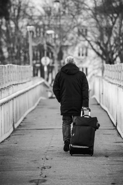 Porträtt på baksidan av gamling vakna på gatan med en resväska — Stockfoto