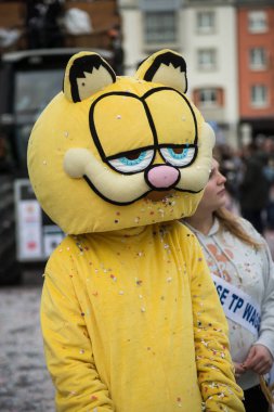 Garfield kedi kostümlü insanlar sokakta geçit yapıyor.