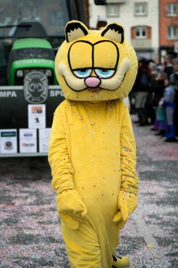Garfield kedi kostümlü insanlar sokakta geçit yapıyor.