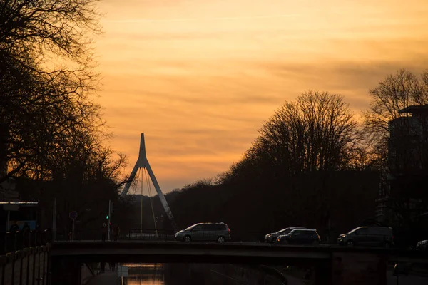 Panorama con sagoma di ponte sospeso sotto il canale con traffico auto entro il tramonto — Foto Stock