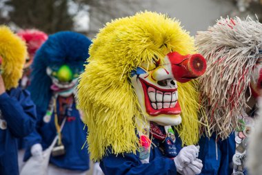 Neuenburg - Almanya - 23 Şubat 2020 - Karnaval maskeli bir grup insan caddede geçit töreni yapıyor