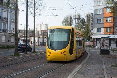 Mulhouse - Fransa - 29 Mart 2020 - Sokakta yuvarlanan sarı tramvay manzarası