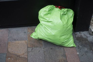 Sokakta yeşil plastik çöp torbalarına yakın çekim.