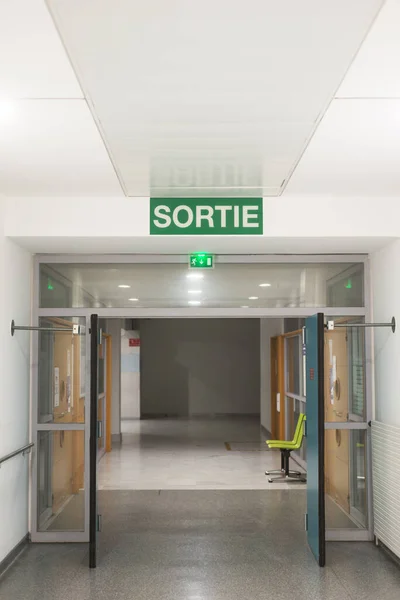 临终关怀走廊的景观 以法语书写出口板 Sortie 出口英语陷阱 — 图库照片