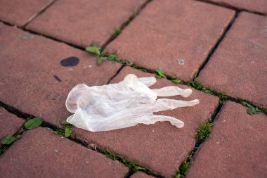 Sokakta bırakılmış kullanılmış lateks eldivenlerin yakın çekimi. 