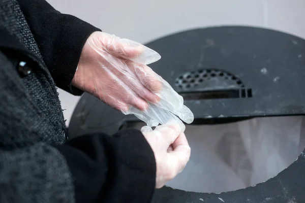 Zbliżenie Rąk Kobiety Wkładającej Używane Rękawiczki Lateksowe Śmieci Ulicy — Zdjęcie stockowe