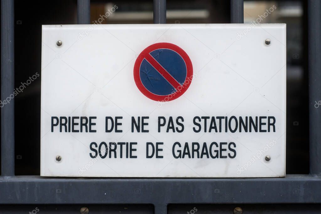 Closeup of no parking panel with text in french priere de ne pas stationner sortie de garage, traduction in english : please do not park outside the garage