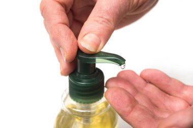 Coronavirus 'a karşı korunmak için beyaz arka planda sıvı sabunla ellerini ezen bir kadının elleri.