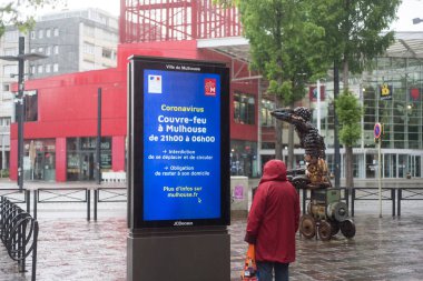 Mulhouse - Fransa - 2 Mayıs 2020 - Coronavirus salgınına karşı bilgi paneline bakan kadının portresi gece boyunca sokağa çıkma yasağı boyunca yayıldı