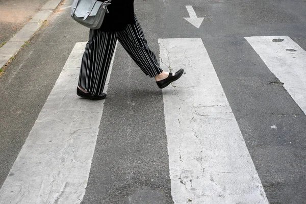 Kavşaktaki Zebra Üzerinde Yürüyen Çizgili Pantolonlu Bir Kadının Bacakları — Stok fotoğraf