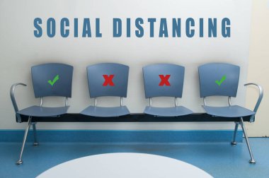 Blues chair alignment in a waiting room with symbol on seat for the social distancing during the Covid-19 pandemic clipart