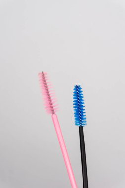 Beyaz arka planda iki renk kirpik fırçası kız ana kirpik uzantısı için.