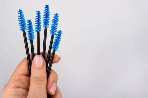 Set of eyelash brushes in hand on white background.