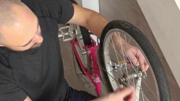 El padre arreglando la Bicicleta de su hija. En interiores. Rueda de reparación y engranajes — Vídeo de stock