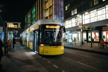 Berlin, Almanya - 7 Aralık 2016. Berlin'in Mitte Orta bölgesinde, sarı tramvay akşam saat içinde. Alexanderplatz İstasyonu.