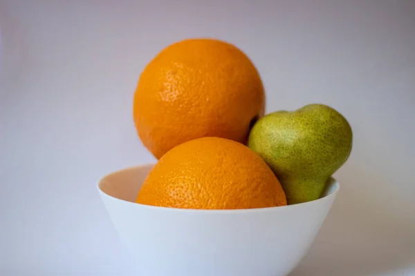 Dos Naranjas Una Pera Sobre Fondo Blanco Aislado —  Fotos de Stock