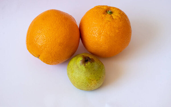 Two oranges and one pear on a white isolated background