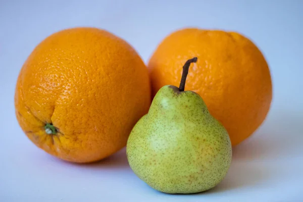 Dos Naranjas Una Pera Sobre Fondo Blanco Aislado —  Fotos de Stock