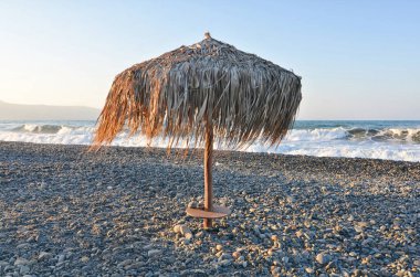 Yunanistan 'da çimen plajı şemsiyeleri gün batımı