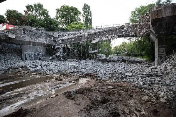 Orange excavator digger demolishing bridge