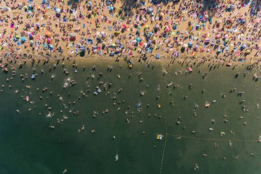 Yaz tatili kumlu sahilde, güneşlenmek ve suda yüzmek.