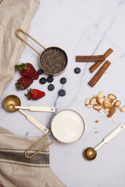 Ölçme Kaşığı, Çilek, Böğürtlen, Badem ve Tarçın ile Ölçme Kadehinde Chia Tohum ve Süt