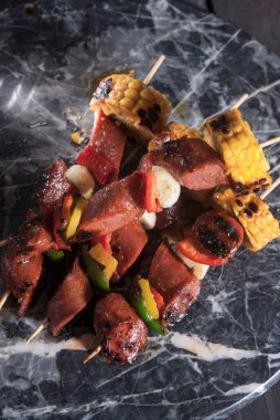 Kızarmış Frankfurter sosisi, mısır, dolmalık biber ve sarımsak.