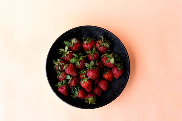 Frische Erdbeeren Einer Schwarzen Schüssel Weißer Blauer Und Oranger Hintergrund — Stockfoto