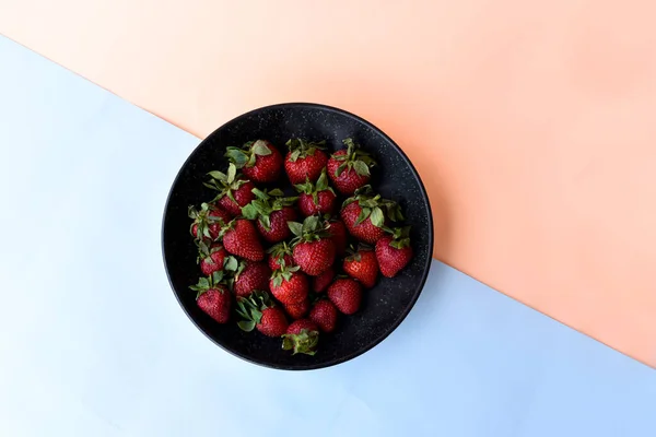 Frische Erdbeeren Einer Schwarzen Schüssel Weißer Blauer Und Oranger Hintergrund — Stockfoto