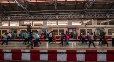 Mumbai, Hindistan - 18 Aralık 2019: Bombay işçi sınıfı için en yoğun tren istasyonlarından biri olan CST istasyonunda platformda yürüyen kimliği belirsiz yolcular