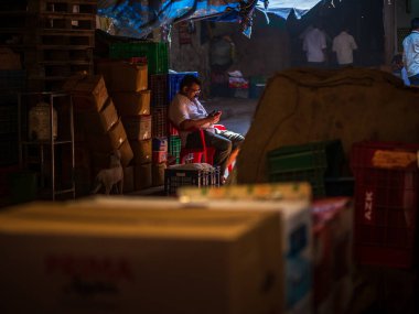 Mumbai, Hindistan - 18 Aralık 2019: Crawford pazarında cep telefonu kullanan tanımlanamayan adam