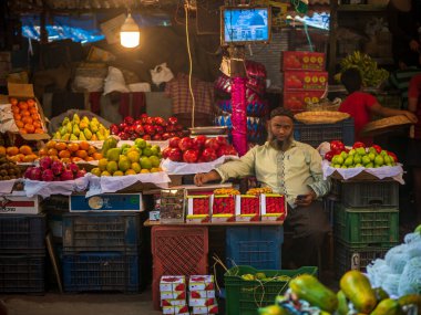 Mumbai, Hindistan - 18 Aralık 2019: Crowford pazarında Müslüman meyve satıcısı. Meyve satıcıları Hint şehirleri ve şehirleri boyunca yol kenarındaki dükkanlarda çeşitli meyveler satıyorlar..
