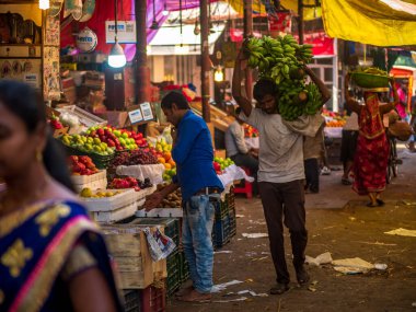 Mumbai, Hindistan - 18 Aralık 2019: Güney Mumbai 'de meyve pazarında muz taşıyan bir hamal
