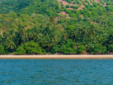 Tarkarli Sahili 'nden mavi suları ve yeşil ağaçları olan Hint Okyanusu manzarası.