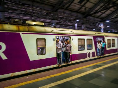 Mumbai, Hindistan - 26 Ocak 2020: Mumbai 'de hareket halindeki yerel trenin kapısında duran kimliği belirsiz yolcular
