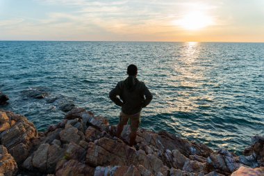 İnsanlar taşın üzerinde durup güneşin batışını izledi..