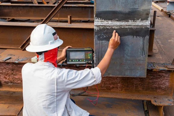 Müfettişler çelik kaynaklarındaki kusurları kontrol ediyor. Endüstriyel fabrikadaki Yıkım Olmayan Test (NDT) 'nin Ultrasonik Test (UT) işlemiyle birleşik ekleme yapıyorlar..