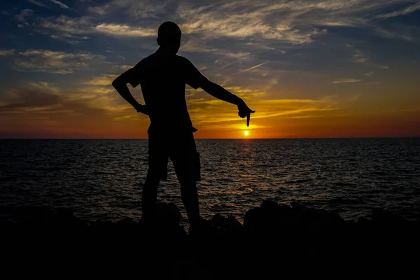 Silhouette Man Standing Points His Finger Sun Seaside Sunset — Stock Photo, Image