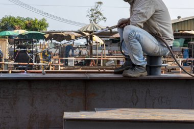 İşçiler kaynak yaptıktan sonra bozulan demiri yakmak için ısıtma meşalesi kullanıyorlar..