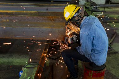 Endüstriyel fabrikada kestikten sonra H-ışını çeliğinin yüzeyini öğütmek için öğütme makinesi kullanılıyor..