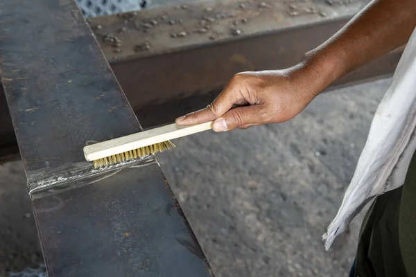 stock image How to use a brush to clean the welding surface before performing Non-Destructive Testing(NDT) for checking defect in welding of steel add joint.