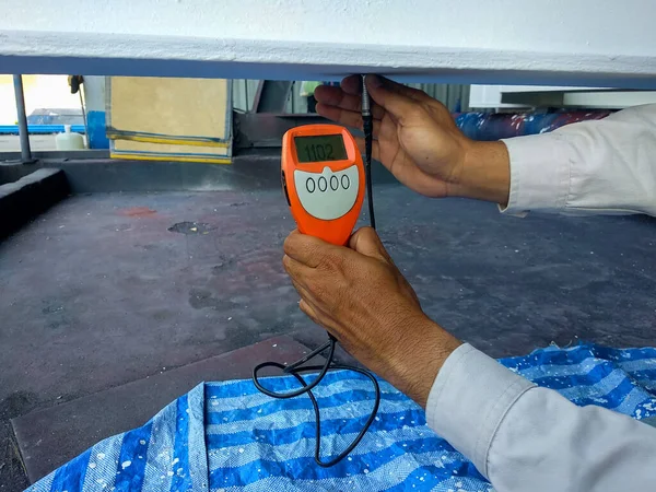 Measure Dry Film Thickness (DFT) with Coating Thickness Gauge for fireproof painting on steel structure, at industrial factory.