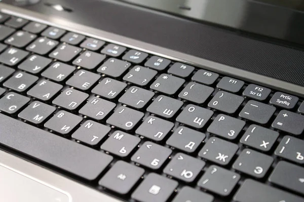 ロシアのキーボードで新しいグレーのラップトップをきれいにする — ストック写真