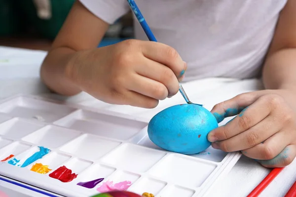 Easter concept, kid painting fancy colorful eggs for Easter event