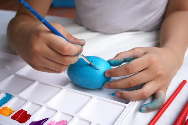 Easter concept, kid painting fancy colorful eggs for Easter event